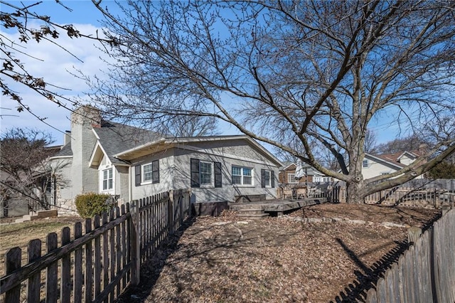 view of front of property with fence private yard and a chimney