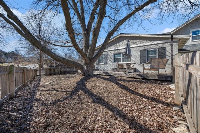 view of home's exterior with a fenced backyard, brick siding, and a deck