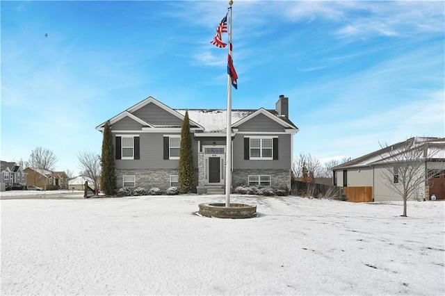 view of front of property with stone siding, a chimney, and fence