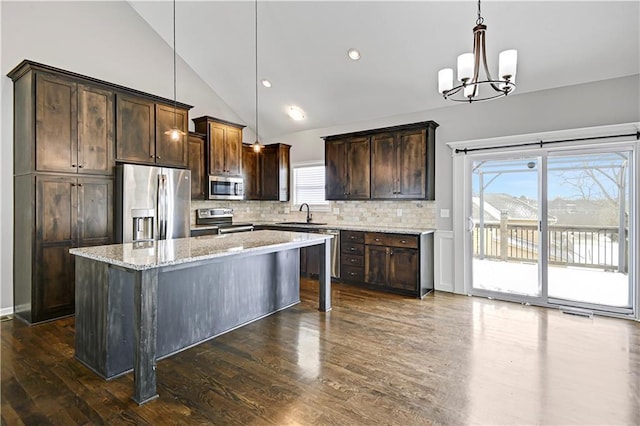 kitchen with stainless steel appliances, dark wood finished floors, dark brown cabinetry, and decorative backsplash