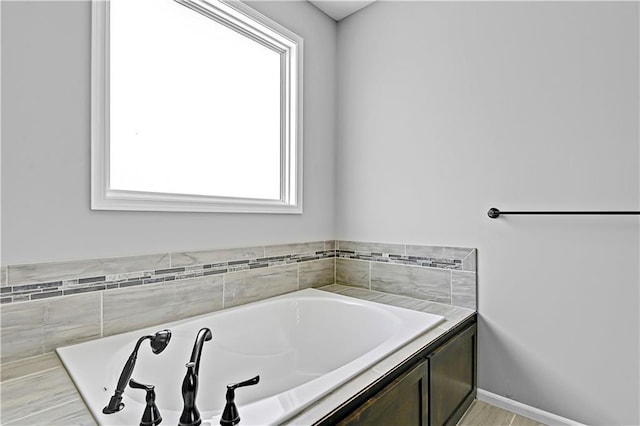 full bathroom featuring a garden tub and baseboards