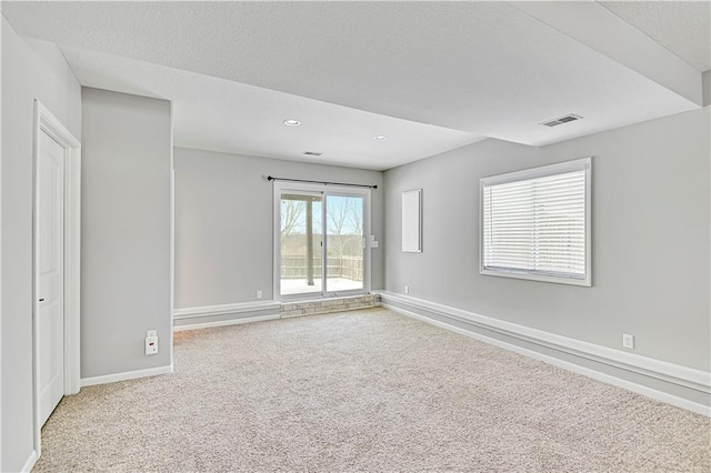 carpeted spare room with recessed lighting, visible vents, a textured ceiling, and baseboards