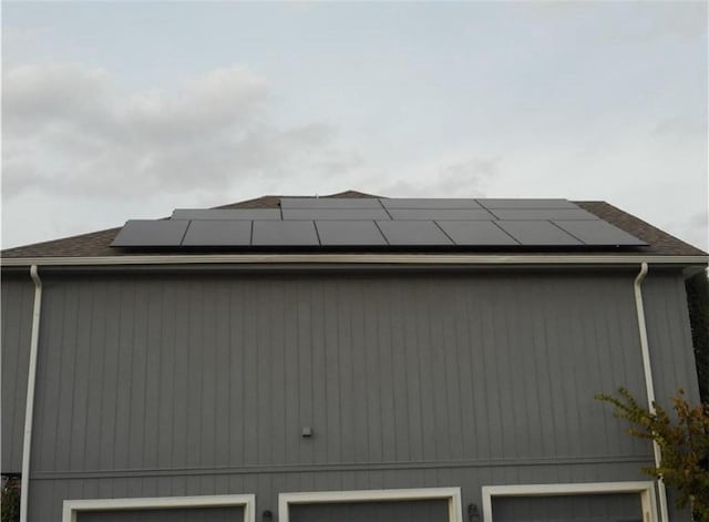 view of property exterior featuring roof mounted solar panels