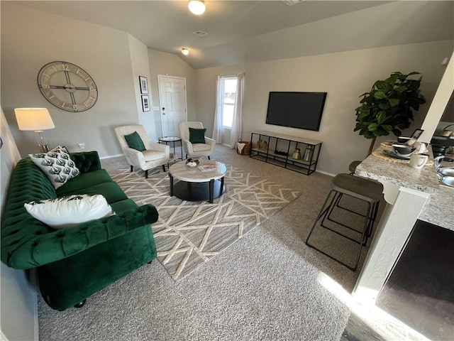 living room with vaulted ceiling, carpet flooring, visible vents, and baseboards