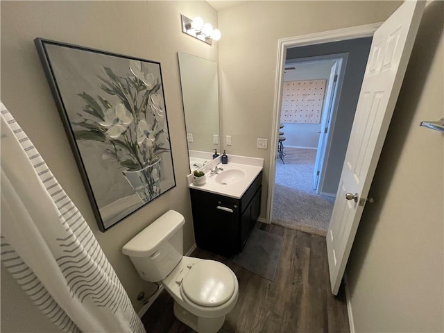 bathroom with toilet, wood finished floors, and vanity