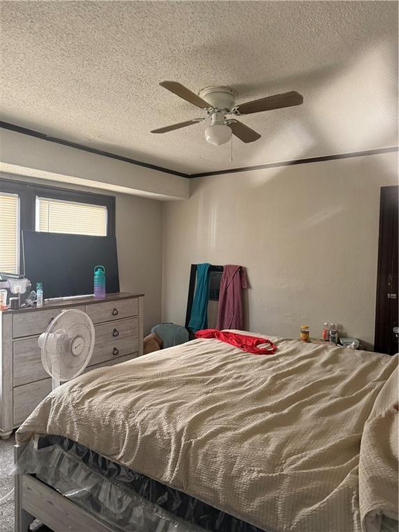 bedroom featuring a ceiling fan and a textured ceiling