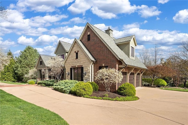 view of side of home with a garage, driveway, and stone siding