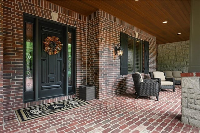 entrance to property with covered porch and brick siding