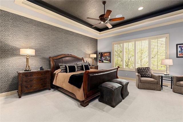 carpeted bedroom with crown molding, baseboards, a ceiling fan, and a tray ceiling