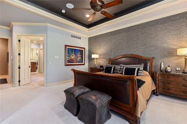carpeted bedroom featuring ceiling fan, baseboards, a tray ceiling, visible vents, and ornamental molding