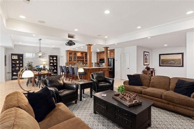 living room featuring crown molding, decorative columns, recessed lighting, a tray ceiling, and bar area