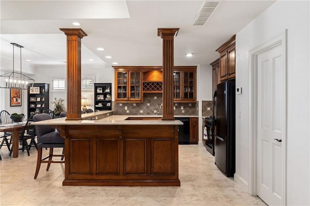 kitchen with visible vents, light countertops, decorative columns, and black appliances