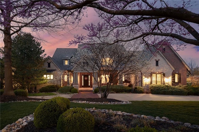 10816 W 140th St, Overland Park, KS 66221 - view of front facade featuring stone siding, a front lawn, and curved driveway