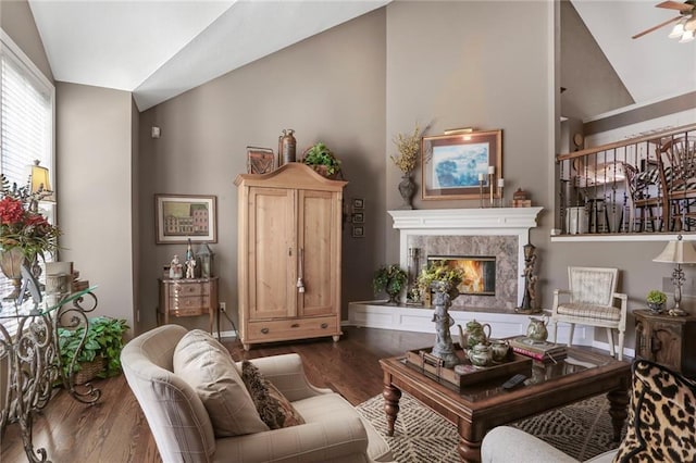 living room with a fireplace, lofted ceiling, wood finished floors, and a ceiling fan