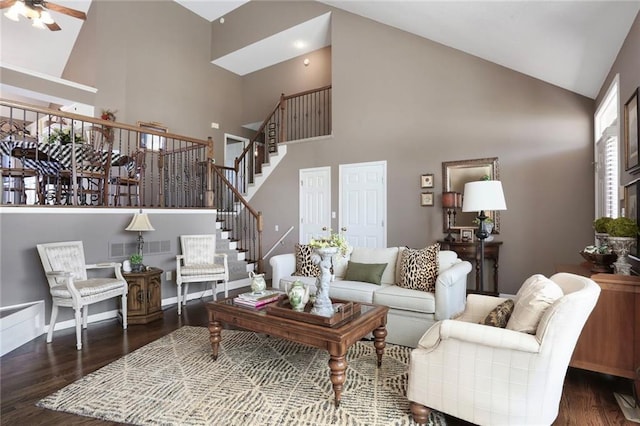 living area featuring ceiling fan, stairway, visible vents, and dark wood finished floors