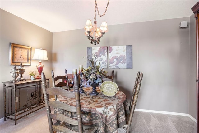 dining room featuring light carpet, baseboards, and an inviting chandelier