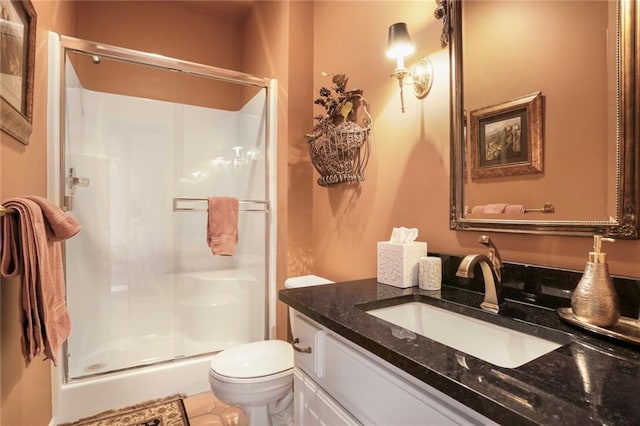 full bathroom featuring a shower stall, vanity, and toilet