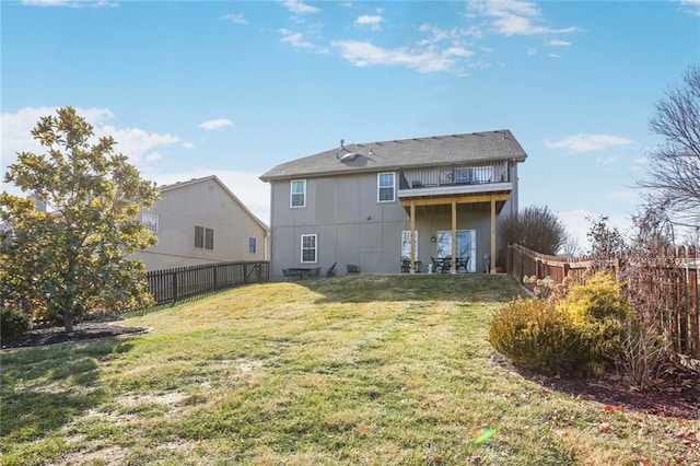 rear view of property with a yard, a fenced backyard, and a balcony