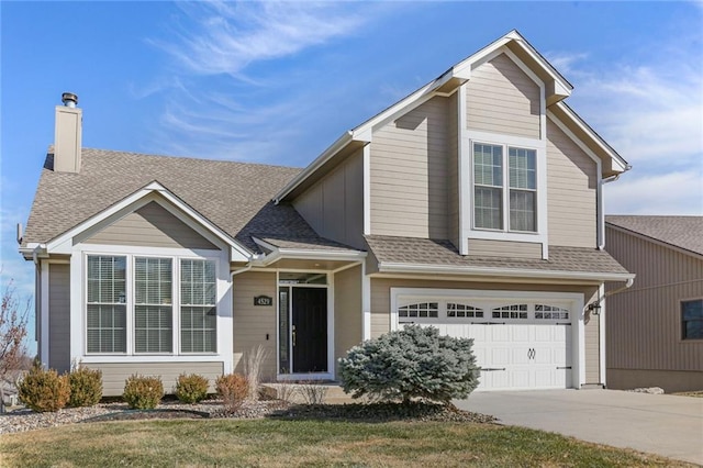 traditional-style home with a chimney, an attached garage, a shingled roof, and driveway