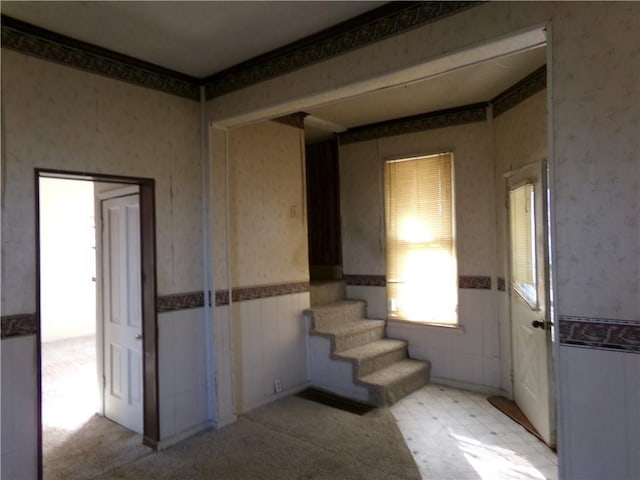 interior space featuring a wainscoted wall and wallpapered walls