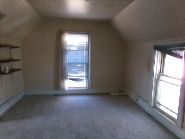 bonus room featuring lofted ceiling, wallpapered walls, baseboards, and carpet flooring