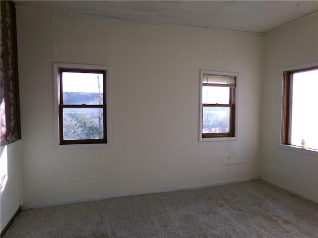 unfurnished room with a healthy amount of sunlight and light colored carpet