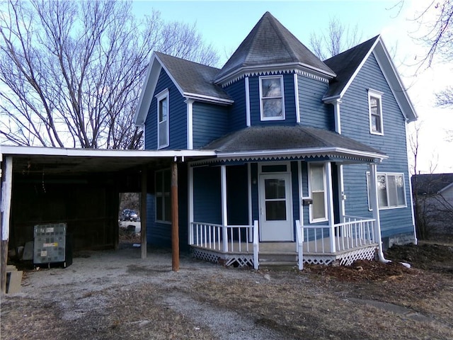 victorian home featuring covered porch and a shingled roof