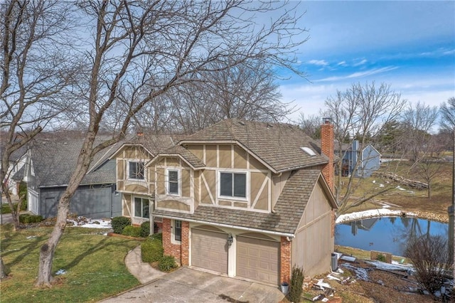 tudor-style house featuring a chimney, stucco siding, concrete driveway, a front lawn, and brick siding