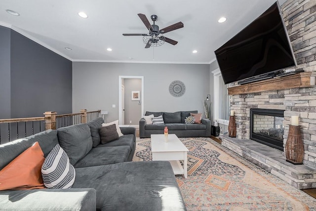 living area featuring a stone fireplace, recessed lighting, a ceiling fan, and ornamental molding