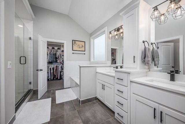 bathroom with a sink, lofted ceiling, two vanities, and a stall shower