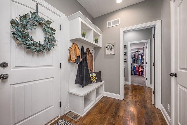 mudroom with visible vents, baseboards, and dark wood-style flooring