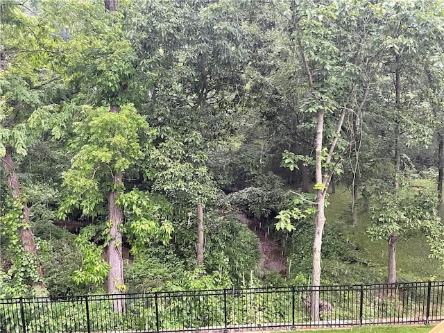 view of yard featuring fence and a wooded view