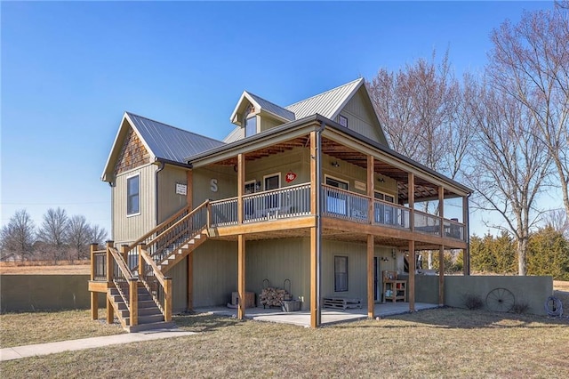 rear view of property featuring stairs, a patio, and metal roof