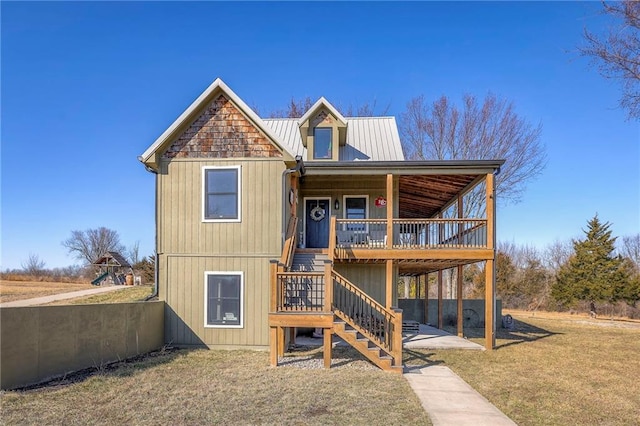 rear view of property featuring a porch, metal roof, stairs, and a yard