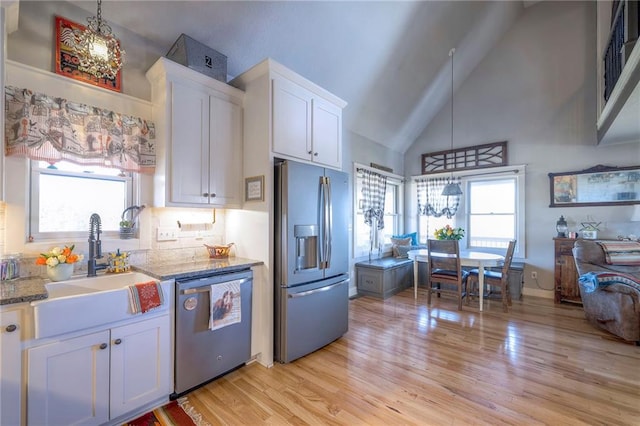 kitchen featuring plenty of natural light, appliances with stainless steel finishes, white cabinetry, and a sink