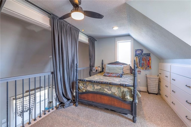 bedroom with a textured ceiling, lofted ceiling, carpet, and a ceiling fan