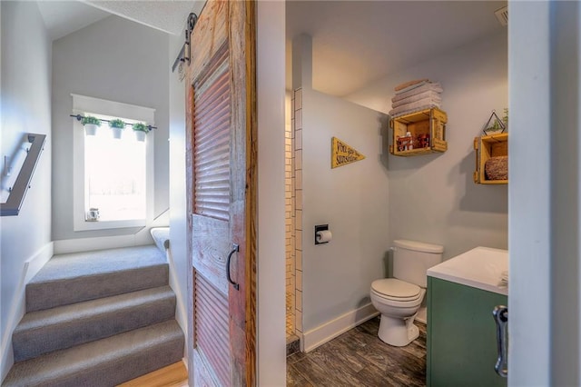 bathroom featuring toilet, wood finished floors, and baseboards