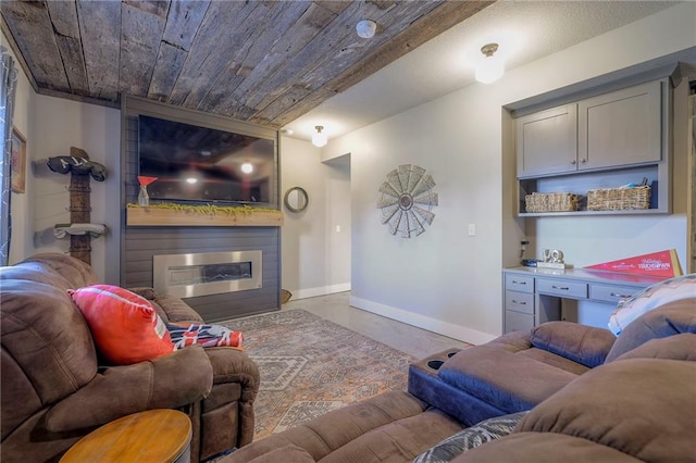 living area with baseboards, wood ceiling, finished concrete flooring, and a fireplace