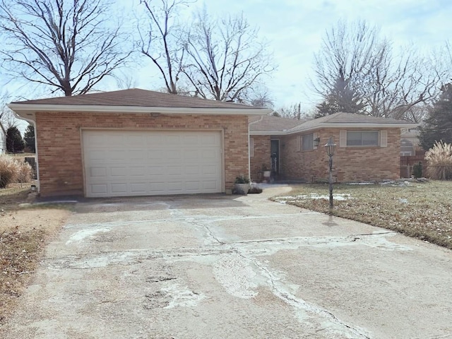 ranch-style house featuring driveway, brick siding, and an attached garage