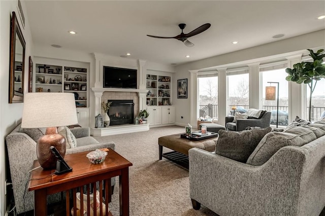 carpeted living room featuring baseboards, built in features, a ceiling fan, a fireplace, and recessed lighting