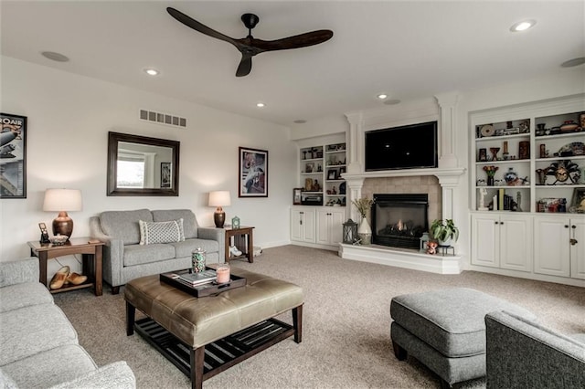 living area with recessed lighting, a fireplace, a ceiling fan, visible vents, and carpet