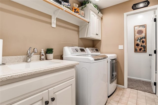 laundry area with light tile patterned floors, cabinet space, a sink, separate washer and dryer, and baseboards