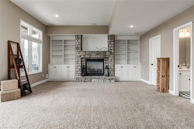 unfurnished living room with carpet floors, a fireplace, baseboards, and recessed lighting