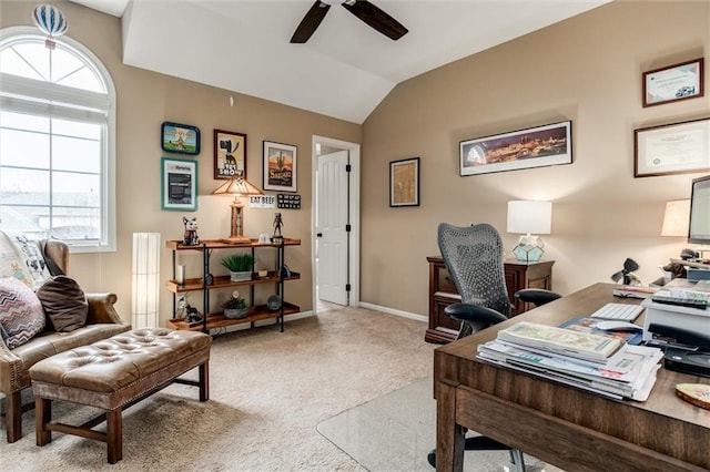 office space with lofted ceiling, baseboards, a ceiling fan, and light colored carpet