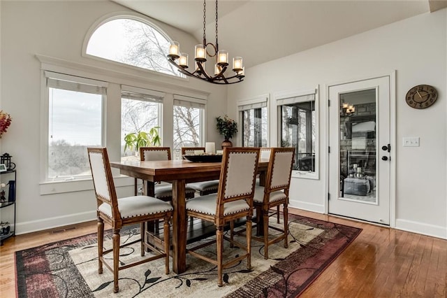 dining area with plenty of natural light, an inviting chandelier, and wood finished floors