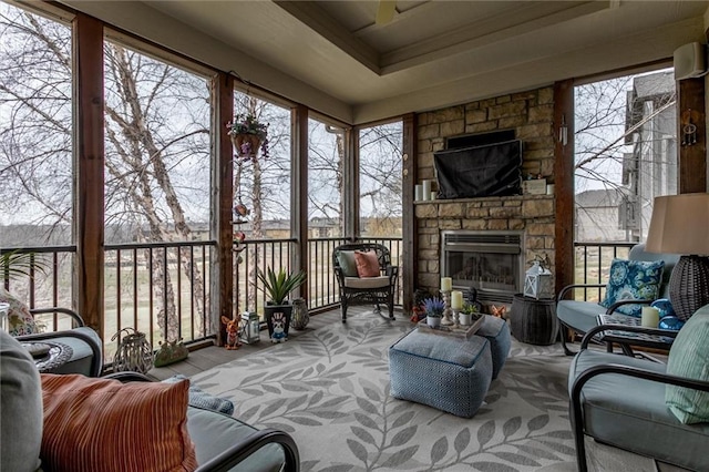 sunroom / solarium featuring a stone fireplace