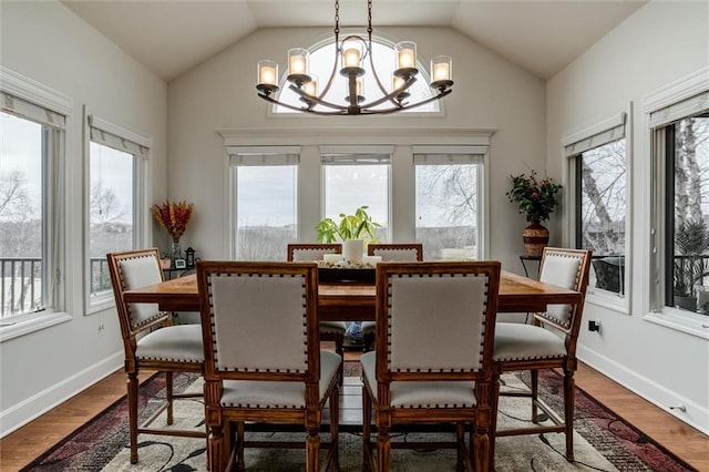 dining space featuring vaulted ceiling, a wealth of natural light, and wood finished floors