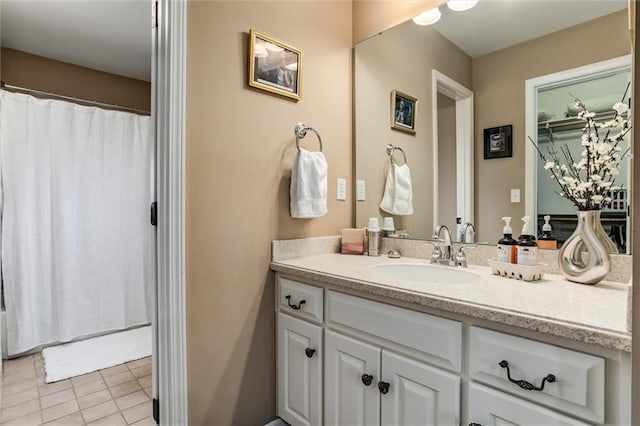 full bath featuring curtained shower, vanity, and tile patterned floors