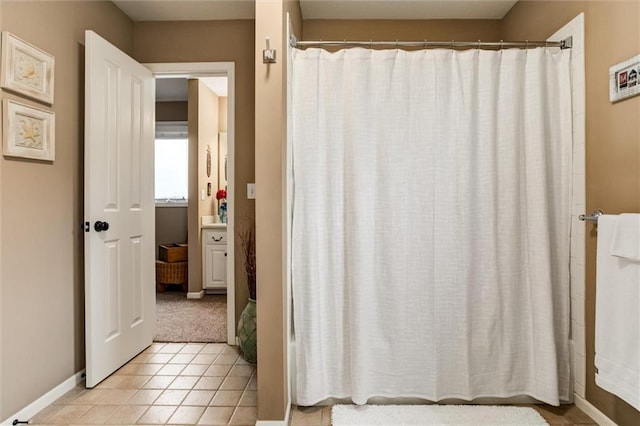 bathroom with curtained shower, baseboards, and tile patterned floors