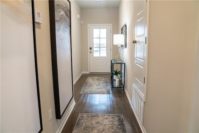 doorway to outside with dark wood-type flooring, visible vents, and baseboards